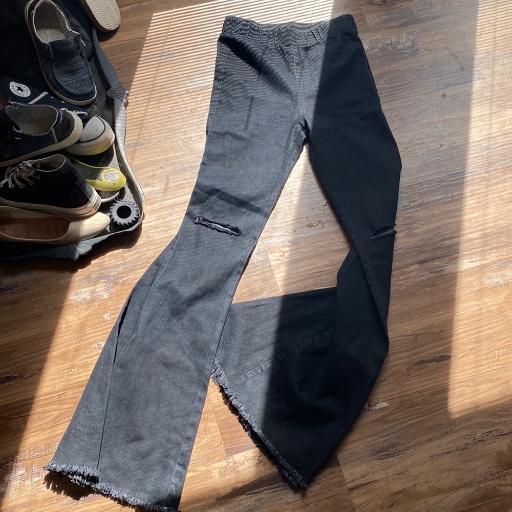 Black bell bottom denim jeans distressed at knees and elastic waistband